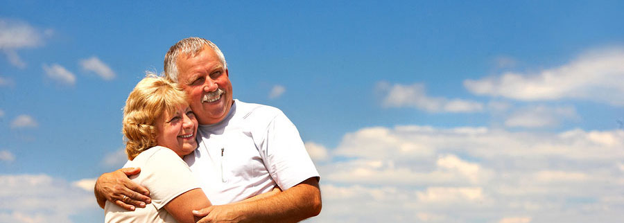 elderly couple posing with sky in the background